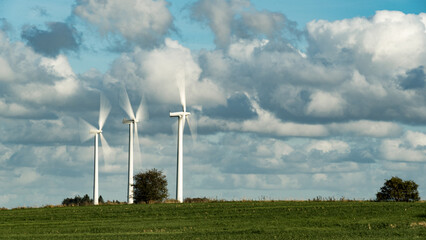Wind turbines on a field under a sunny autumn sky photographed with exposure time and motion blur...