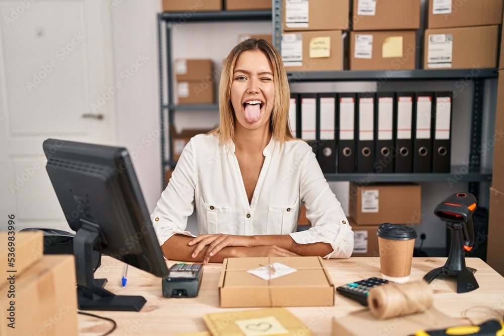 Canvas Prints young blonde woman working at small business ecommerce sticking tongue out happy with funny expressi