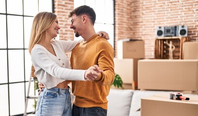 Young man and woman couple smiling confident dancing at new home