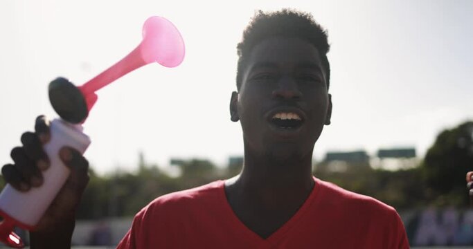 African red sport fan supporting team - Football supporter having fun at competion event - Champions and winning concept