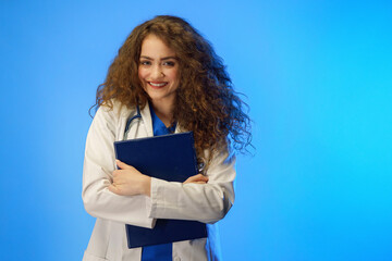 Obraz premium Studio shot of a young female doctor looking at camera against a blue background.
