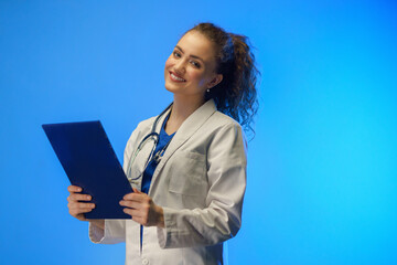 Obraz premium Studio shot of a young female doctor looking at camera against a blue background.