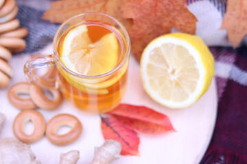 Top view of a cup of tea with lemon, ginger and bagels. Autumn composition, picnic. Warm drink in autumn, selective focus of items