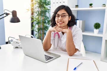 Young latin woman wearing doctor uniform working at clinic