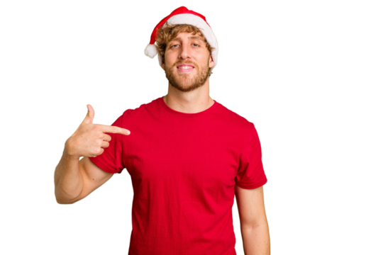 Young caucasian man wearing a Christmas Santa hat isolated on white background person pointing by hand to a shirt copy space, proud and confident