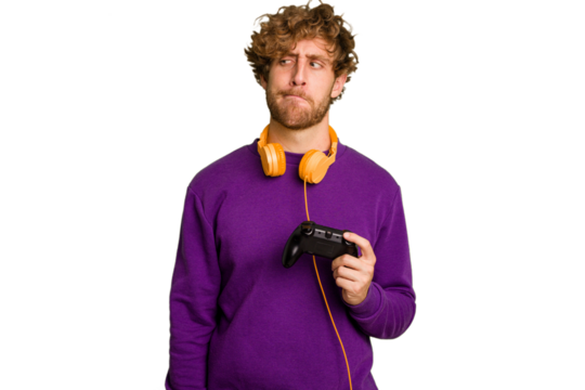 Young caucasian gamer man holding a game controller isolated on white background confused, feels doubtful and unsure.