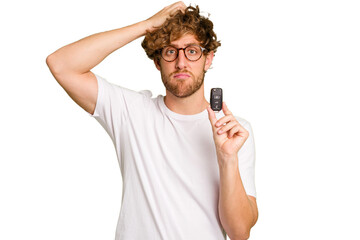 Young caucasian man holding car keys isolated on white background being shocked, she has remembered important meeting. - obrazy, fototapety, plakaty