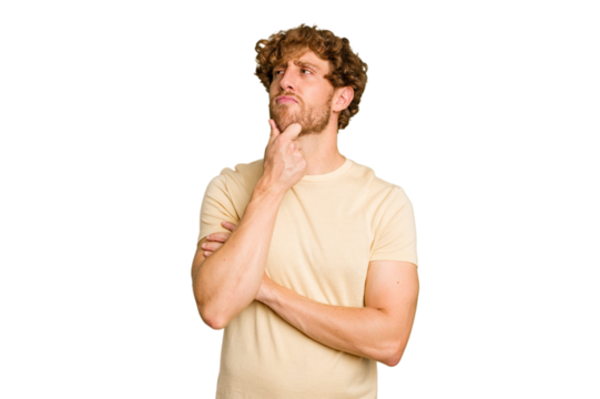 Young caucasian man isolated on green chroma background looking sideways with doubtful and skeptical expression.