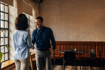 Two people at the office, shaking hands with each other.