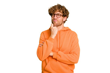Young caucasian man isolated on green chroma background looking sideways with doubtful and...