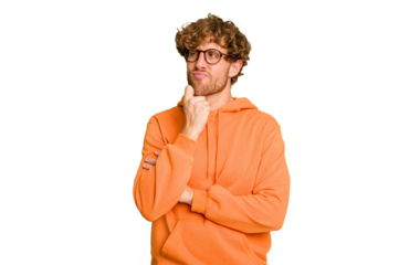 Young caucasian man isolated on green chroma background looking sideways with doubtful and skeptical expression.