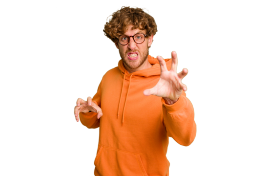 Young caucasian man isolated on green chroma background showing claws imitating a cat, aggressive gesture.