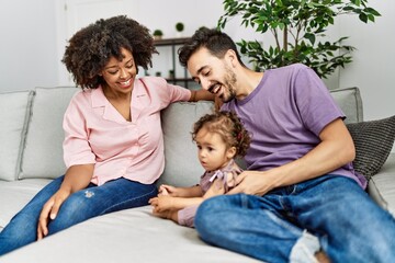 Couple and daughter smiling confident sitting on sofa at home