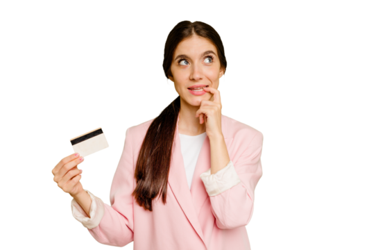 Business caucasian woman holding a credit card isolated relaxed thinking about something looking at a copy space.