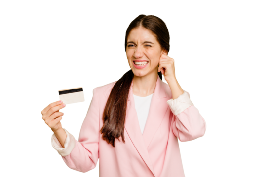 Business caucasian woman holding a credit card isolated covering ears with hands.