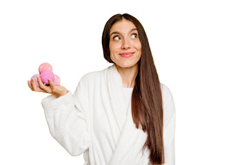 Young caucasian woman holding aromatic balls isolated dreaming of achieving goals and purposes