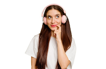 Young caucasian woman wearing headphones isolated relaxed thinking about something looking at a copy space.