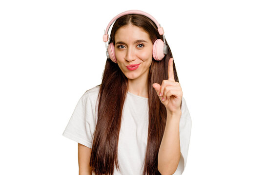 Young caucasian woman wearing headphones isolated showing number one with finger.