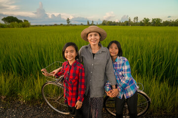 Mother and daughter looking rice field on flooding in countryside