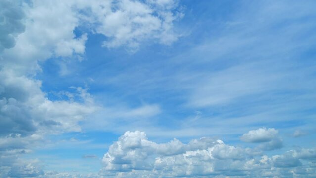 Light high clouds slide on sky. Layer of clouds in blue sky moving horizontal in opposite direction. Timelapse.