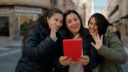 Mother and daugthers having video call hugging each other at street