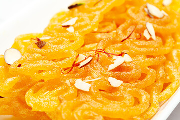Close-Up of Indian Classical  Sweet Jalebi . Garnished with kesar (Saffron) and dry nuts, Jalebi is one of the most delicious sweets widely used in India. Selective Focus on Subject,