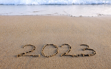 New year 2023 handwritten in the sand surface