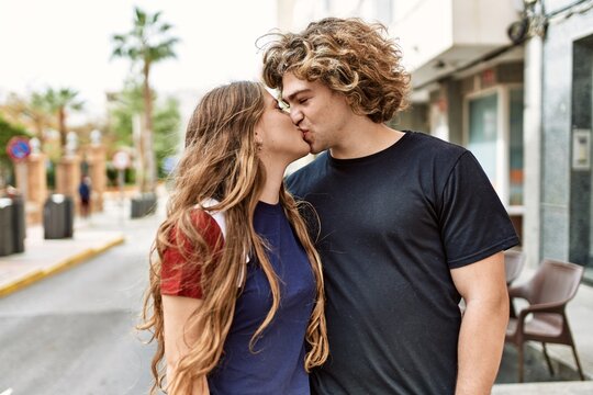 Young caucasian couple kissing and hugging at the city.