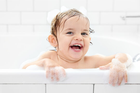 Portrait of young child laughing in bathtub