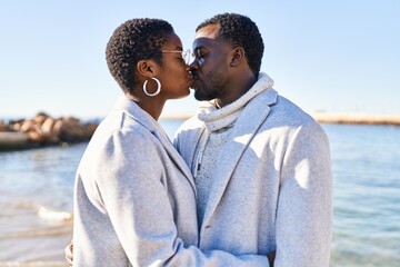 Man and woman couple hugging each other and kissing at seaside