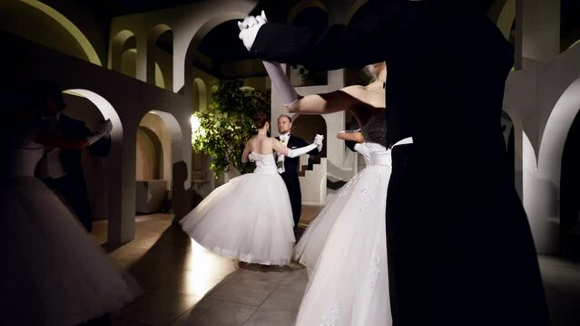 people are dancing in ballroom, beautiful women and men are whirling in waltz, prom night