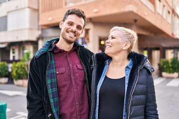 Mother and son smiling confident standing together at street