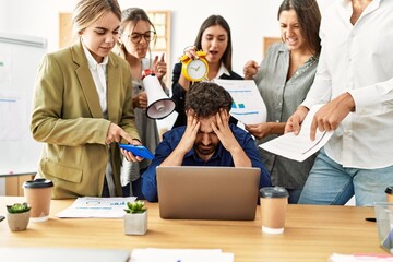 Group of business workers screaming to stressed partner at the office.