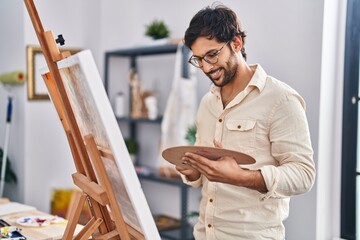 Young hispanic man artist smiling confident drawing at art studio