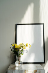 Poster frame mockup and vase with flowers. Blank photo frame with copy space