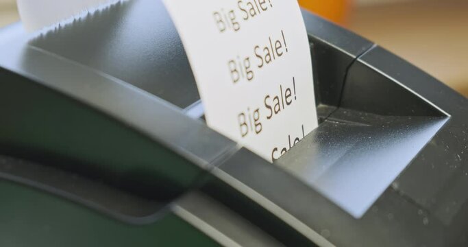 Receipt printer prints text: big sale. Close-up, side view. The concept of promotions, sales in stores.