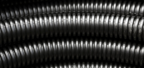 Plastic corrugated pipe. Construction background black tube - obrazy, fototapety, plakaty