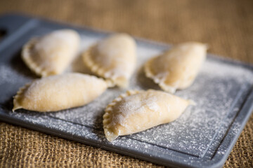 Raw dumplings . Dumplings cooking on a kitchen cutting board.