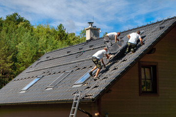 Men worker installing solar photovoltaic panels on roof, alternative energy, saving resources and sustainable lifestyle concept.