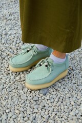 Female feet wearing wallabees  Clark shoes