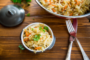 Braised cabbage with carrots, onions and herbs in a ceramic bowl