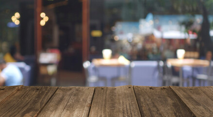 Obraz na płótnie Canvas Wood top table with Blur coffee shop or cafe restaurant with abstract bokeh light image background. People in store Blur Background or design key visual layout