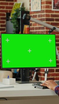 Vertical video: Office worker analyzing isolated greenscreen template on personal computer, looking at blank chroma key display on monitor. Watching pc desktop with mock up copy space background
