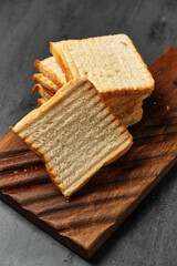 white bread toasts on a board on a black background