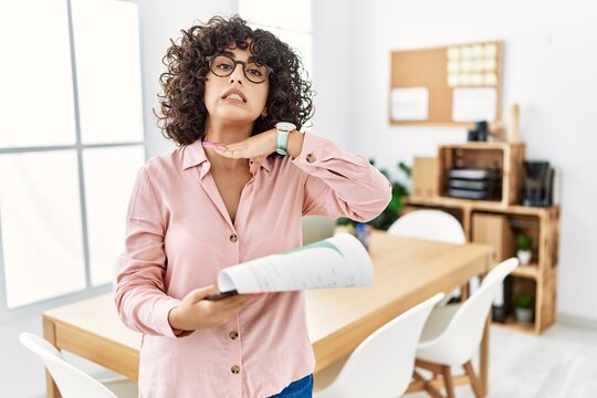 Young middle eastern woman wearing business style at office cutting throat with hand as knife, threaten aggression with furious violence