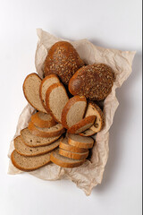 mix of different types of bread in a basket on a white background