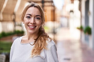 Fototapeta premium Young woman smiling confident standing at street
