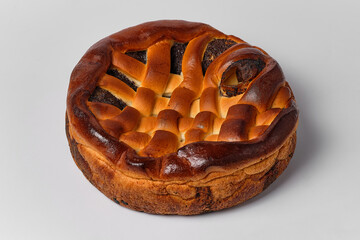 braided pie with poppy seeds on a white background, close view