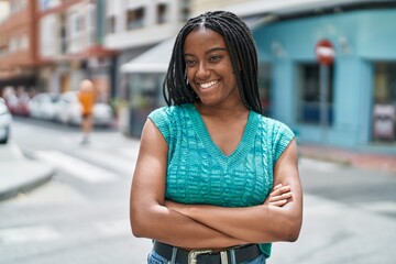 Fototapeta premium African american woman smiling confident standing with arms crossed gesture at street