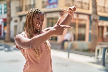 African american woman smiling confident doing photo gesture with hands at street